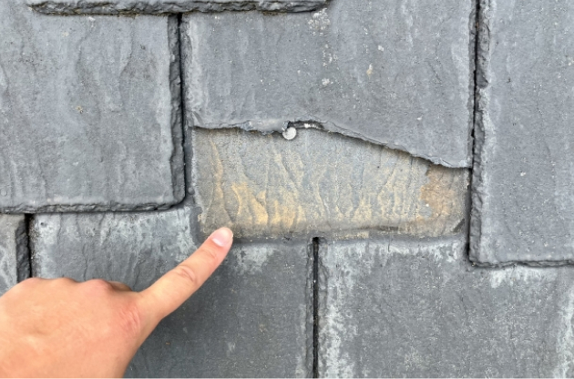 割れた屋根を指差している手